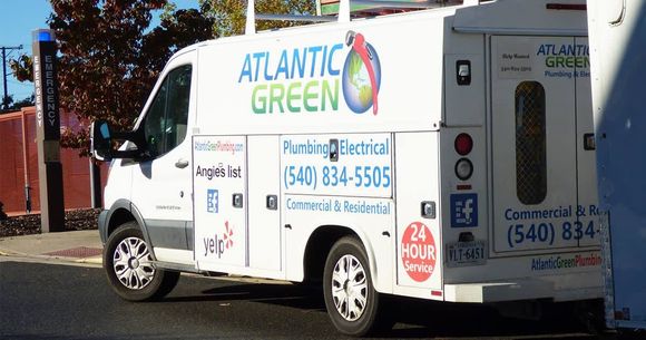 A white work van parked on a street with 
