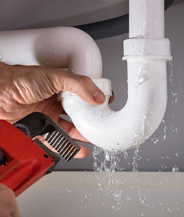 Plumber Repairing A Leaking Sink Drain Pipe
