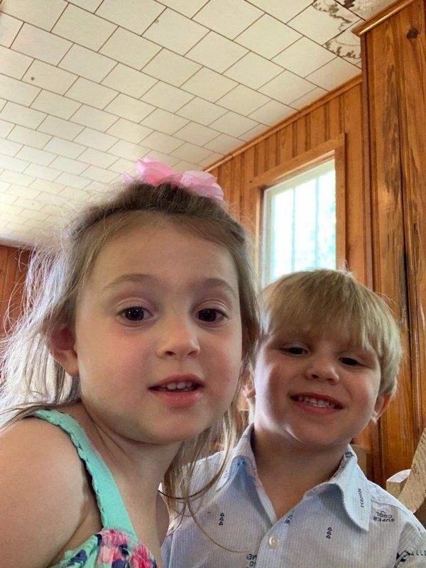 A boy and a girl are posing for a picture together