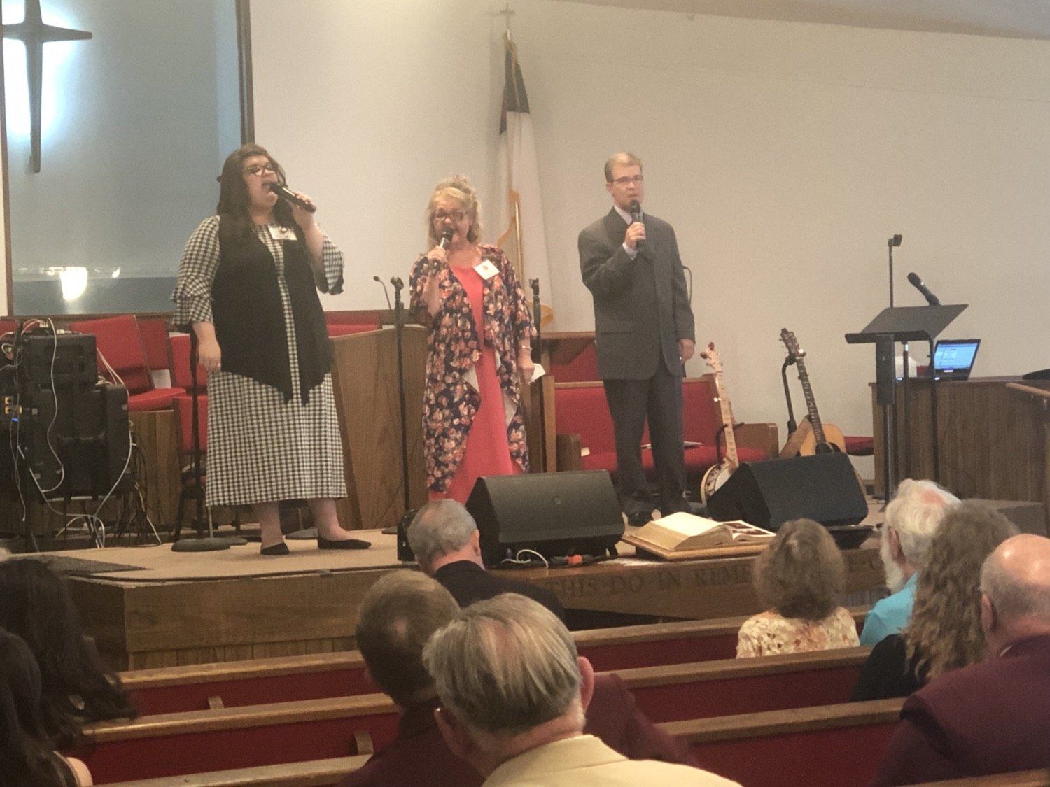 A group of people singing into microphones in a church