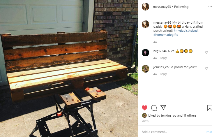 A wooden bench is sitting on top of a workbench in front of a garage door.