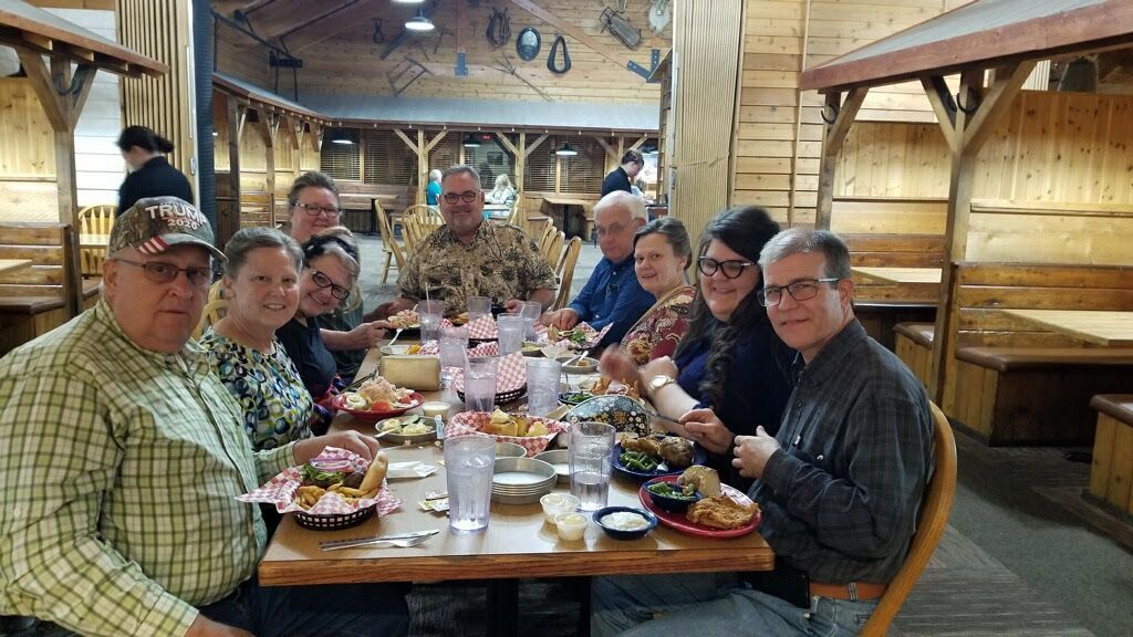 A group of people are sitting at a table in a restaurant eating food.