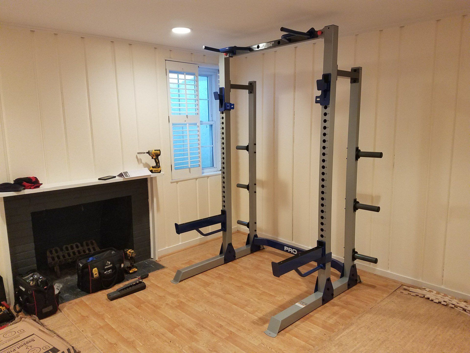A room with a fireplace and a squat rack in it.