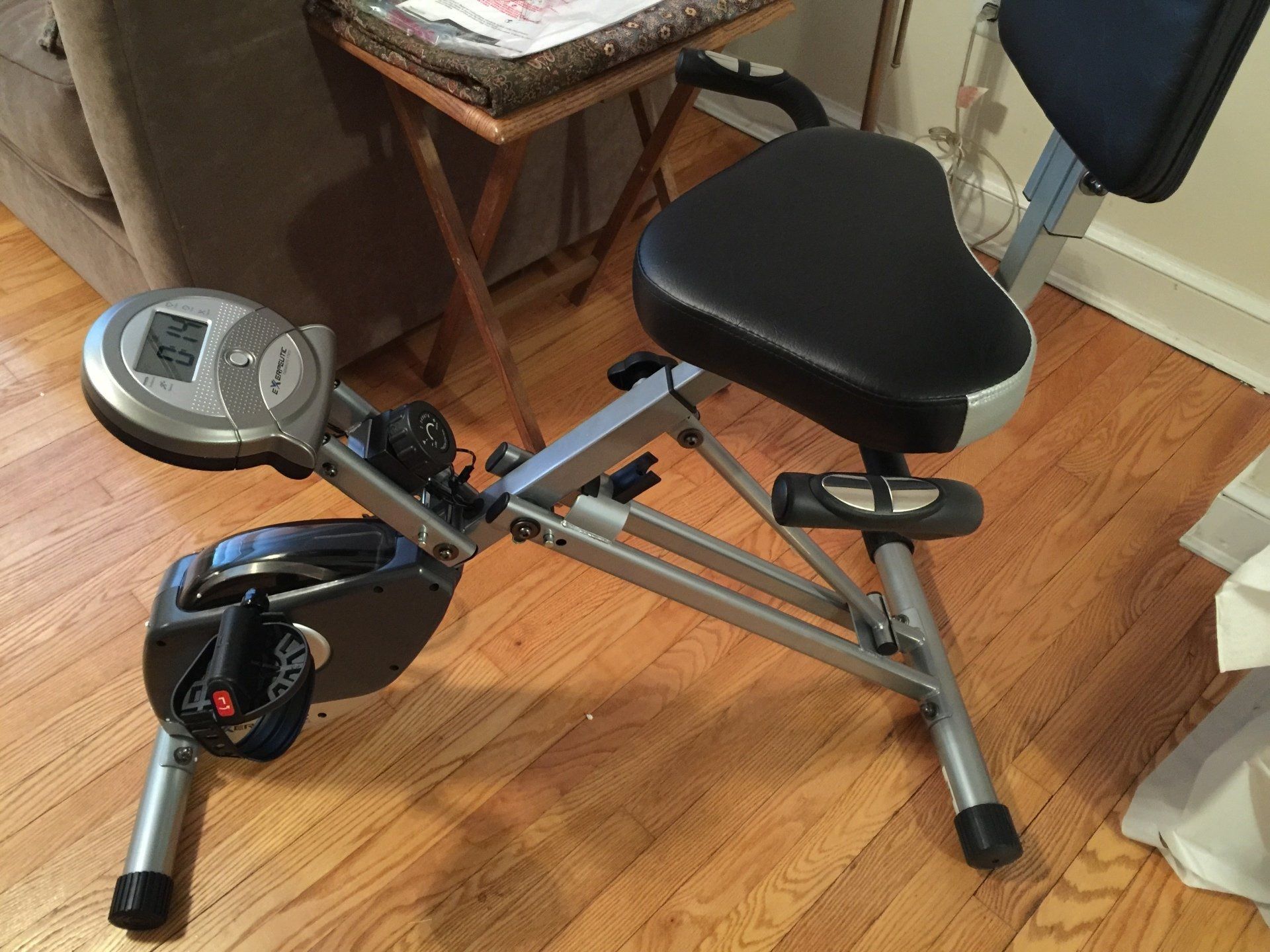 An exercise bike is sitting on a wooden floor in a living room.