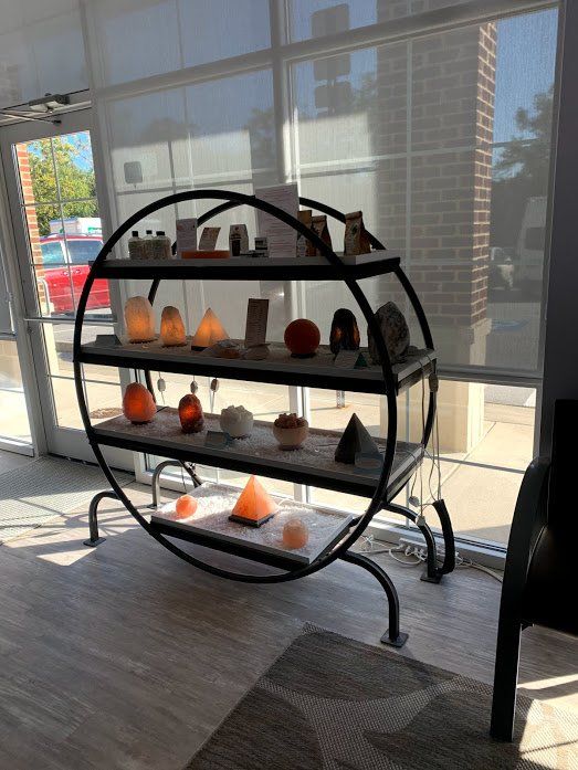 A shelf with candles on it is in a room next to a window.