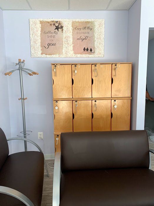 A waiting room with lockers and a chair