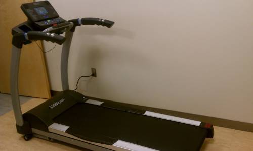 A treadmill is sitting on the floor in a room.