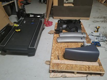 A treadmill parts is sitting on top of a wooden pallet.