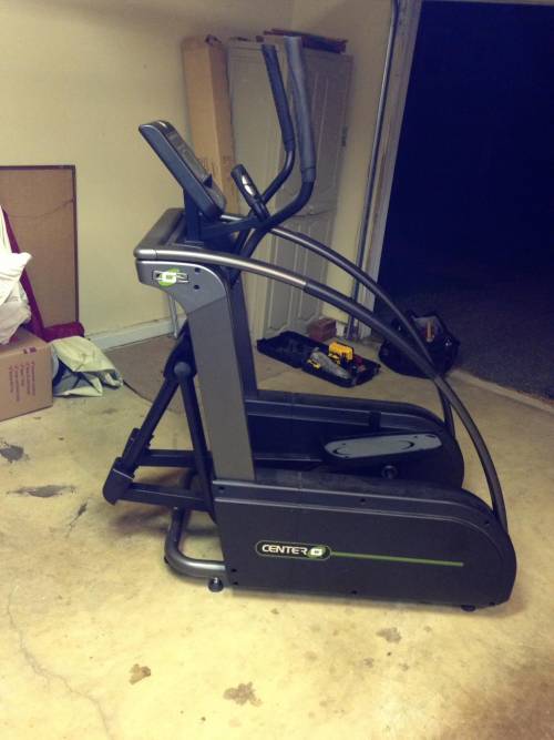 An True elliptical machine is sitting on the floor in a garage
