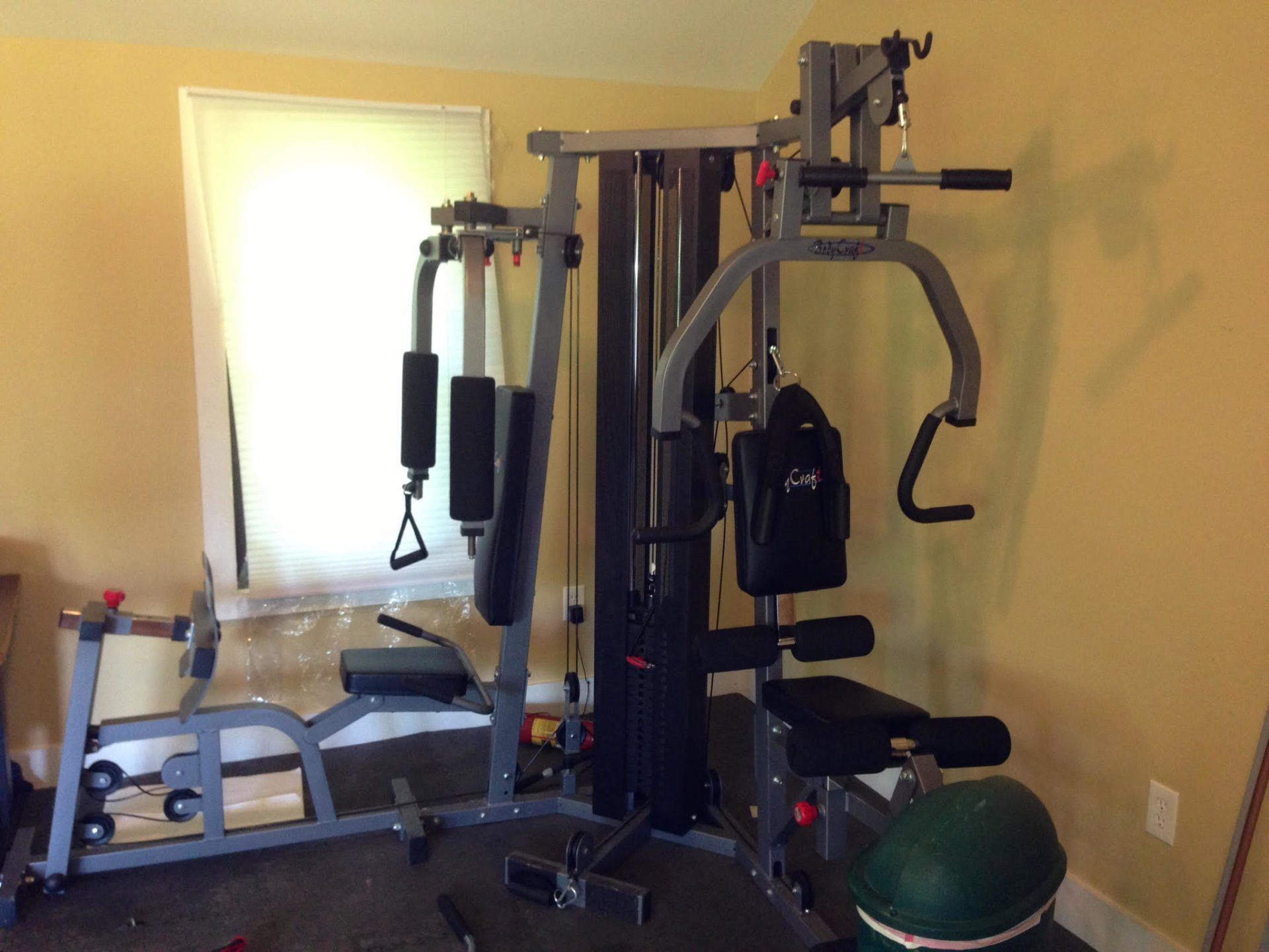 A gym machine is sitting in a room next to a window