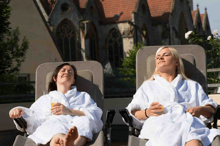 Zwei Freundinnen sonnen sich auf einer Wellness Liege