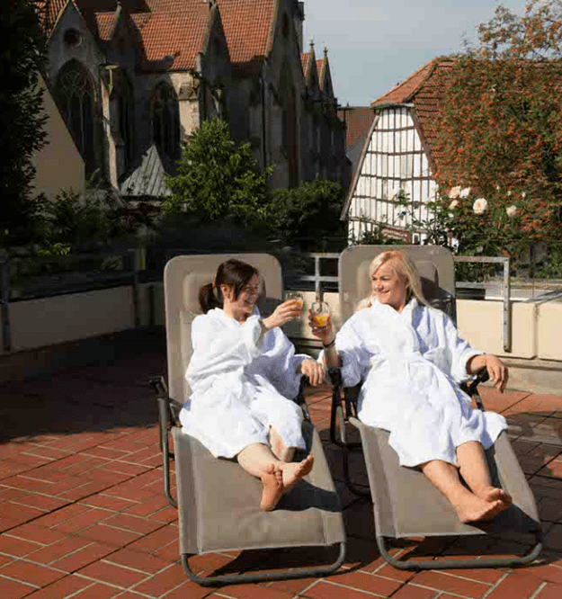 Zwei Freundinnen stoßen beim Wellness auf der Liege an