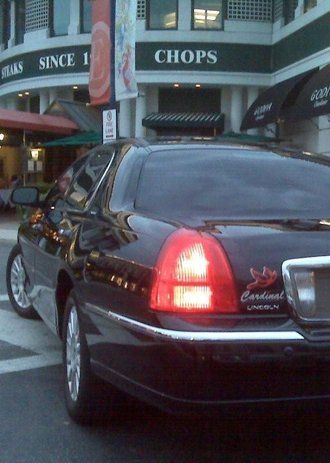 Black Lincoln sedan parked outside a restaurant,