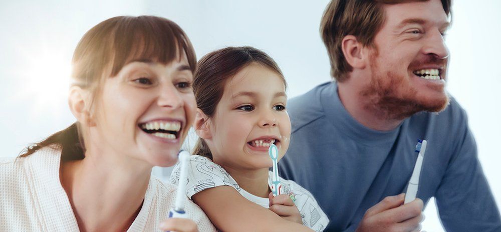 family brushing teeth together