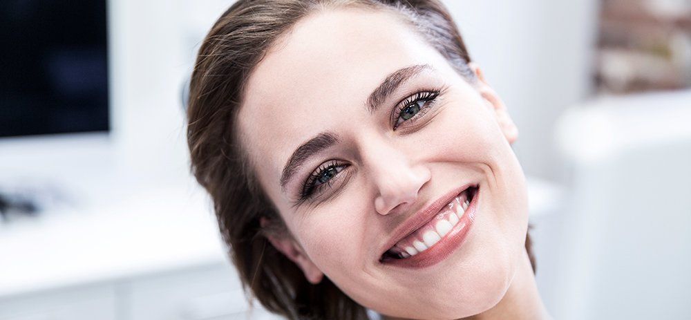 A smiling woman at a dentist office in Christies Beach