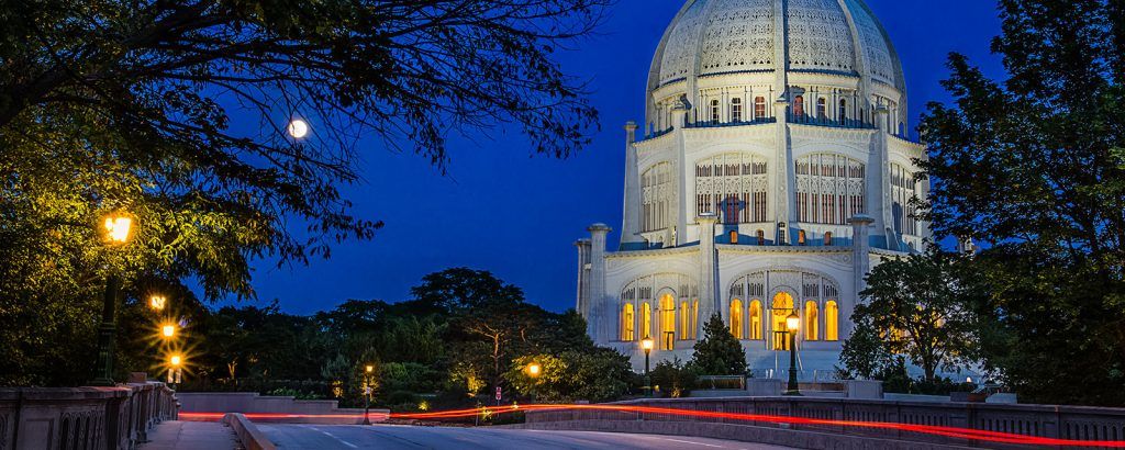 A large building with a dome is lit up at night.