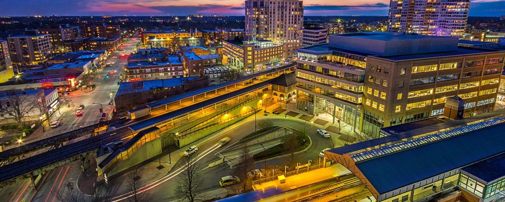 An aerial view of a city at night with a river in the foreground.