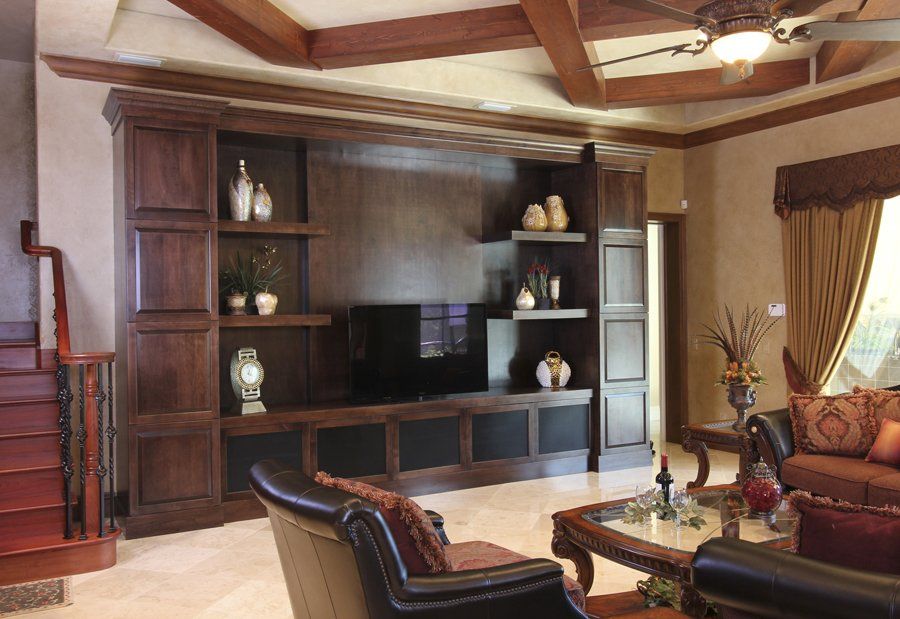 Dark stained wood entertainment center in living room with diagonal ceiling beams.