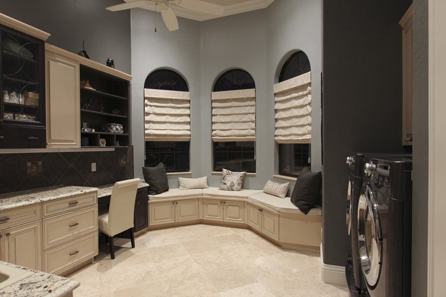 Cozy laundry room with bench seat. Raised panel doors on frameless European cabinetry.