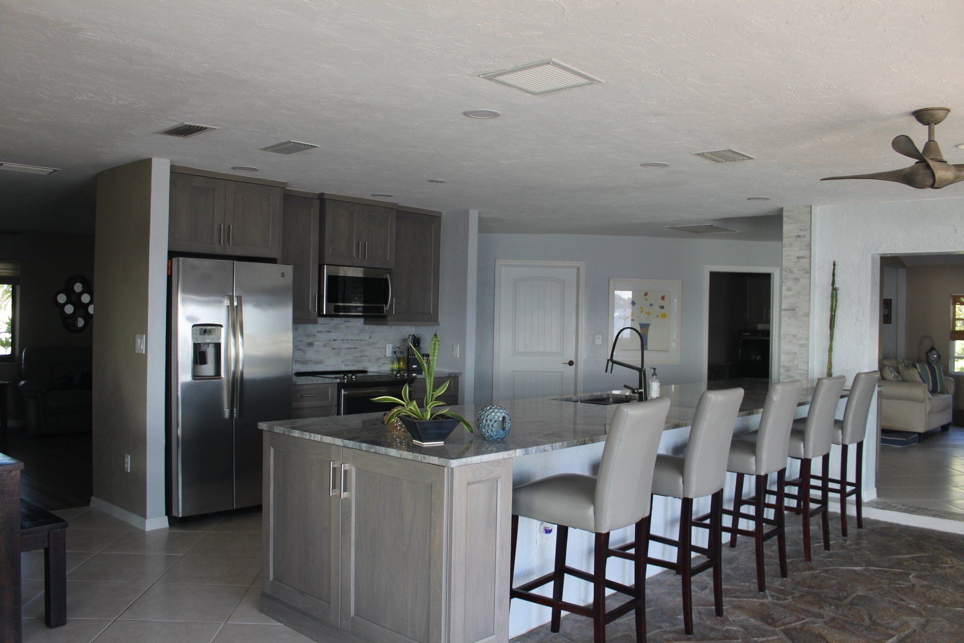 Dark and light grey stained shaker cabinetry. Kitchen remodel with large seating bar area.