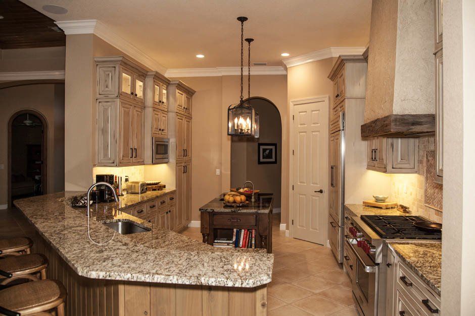 Faux  candle light fixtures above dark stained accent island in rustic kitchen remodel