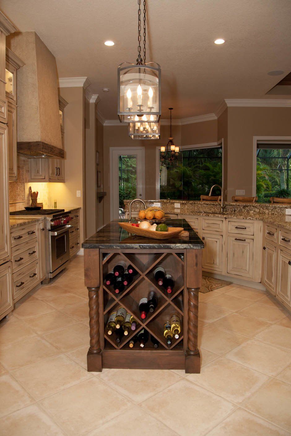 Inset raised panel weathered cabinetry with wine rack on the end of an accented island.