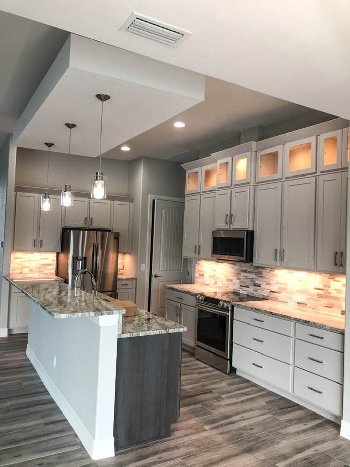 Illuminated stacked wall cabinets with glass doors. Large pots and pans drawers in kitchen remodel.