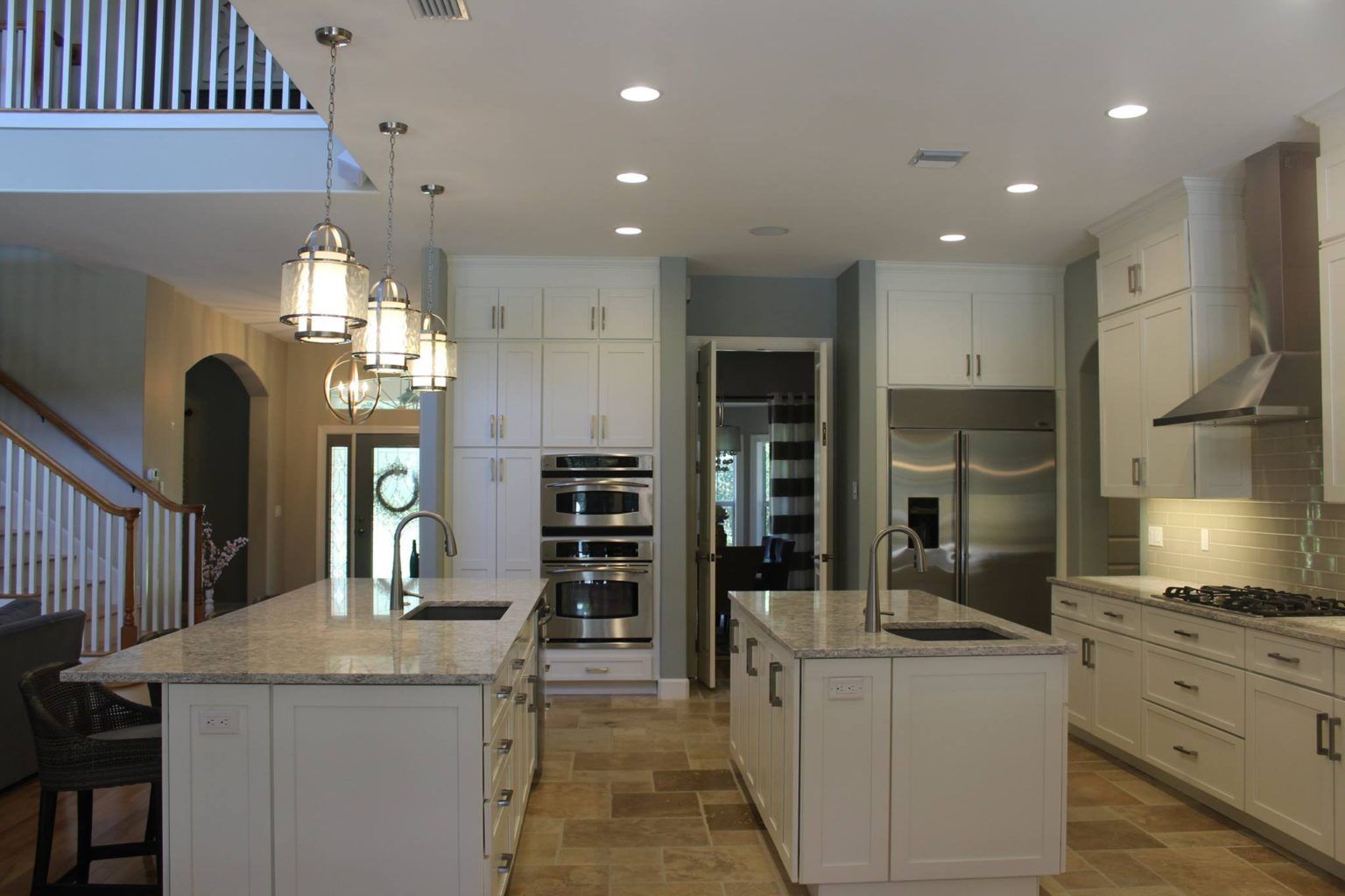 Two island kitchen with impressive storage capacity. White painted shaker cabinets with stainless appliances.