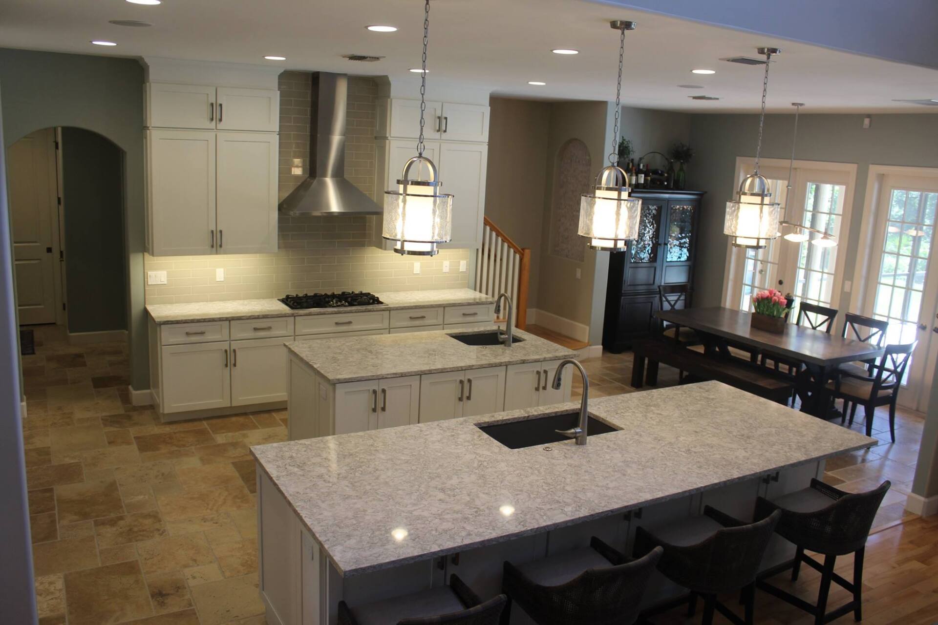 White cabinetry in large kitchen with prep island and large island with seating.