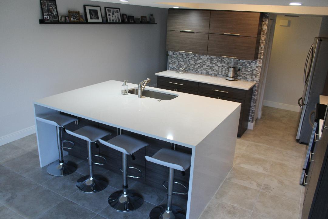 White quartz countertops with waterfall edge on the island of this kitchen remodel.