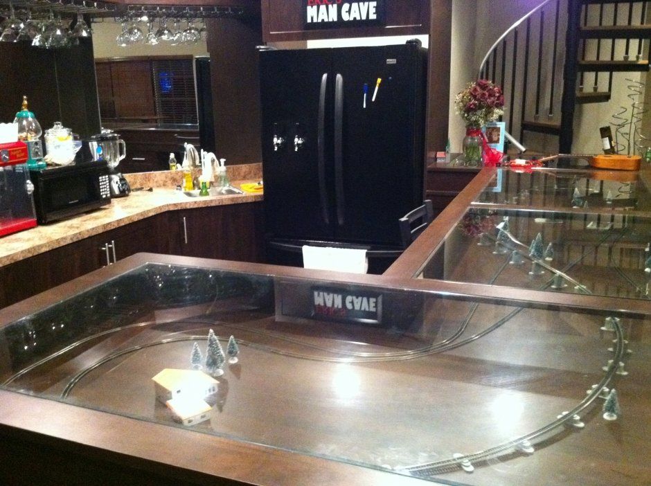 Closeup of man cave bar with custom glass display top at the bar area.