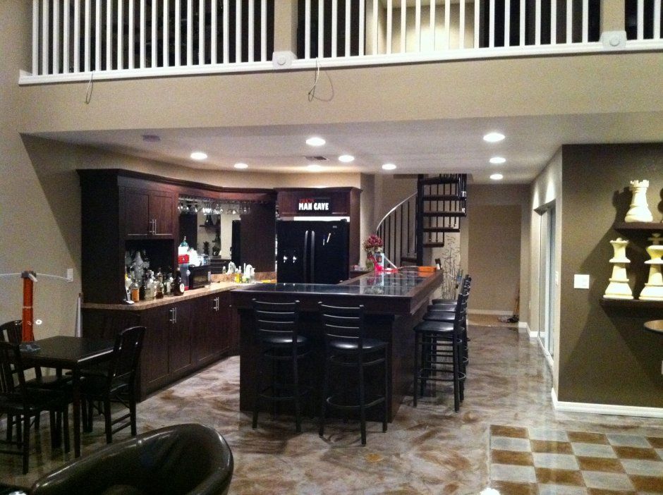 Stunning dark stained shaker style cabinetry with crown molding. Man cave/bar area with stemware holders.