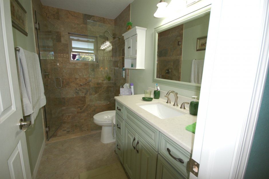 Clear glass shower walls with wall tile. Raised panel cabinetry in bathroom remodel.