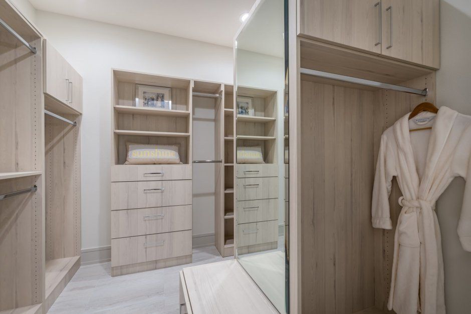 Light wood grain contemporary closet remodel. European style closet cabinetry