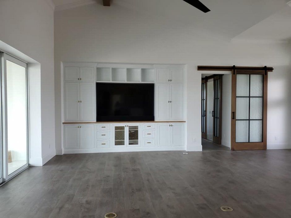 White built-in entertainment center with glass door inserts. Inset face framed cabinetry.