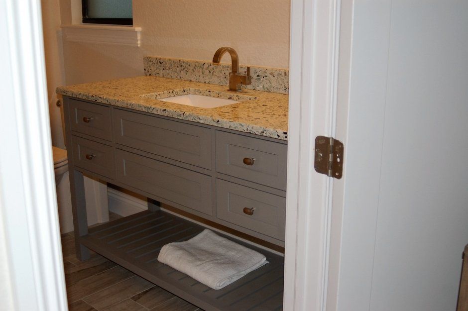 Mission style grey shaker vanity with quartz countertop and brass faucet. Porcelain undermounted sink.