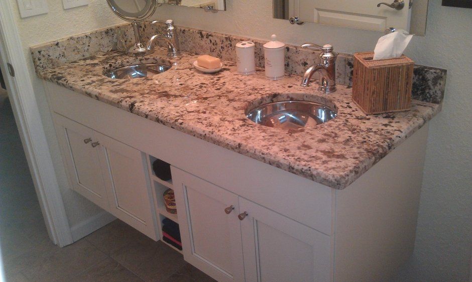 Floating vanity cabinet in bathroom remodel complete with stainless undermounted circular sinks.