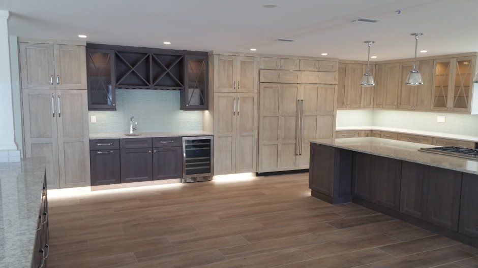 Dark stained accented wet bar and island. Built in refrigerator and freezer with matching cabinet doors.