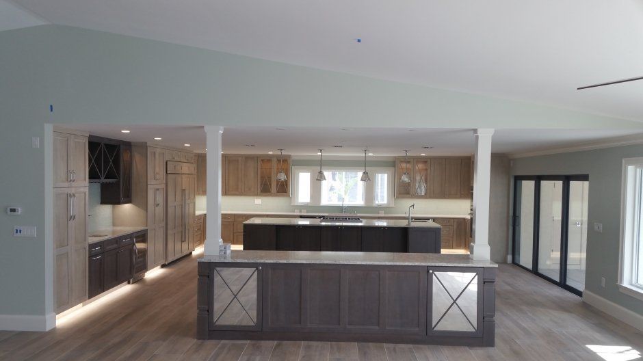 Mirrored doors on buffet cabinetry overlooking a large kitchen. 