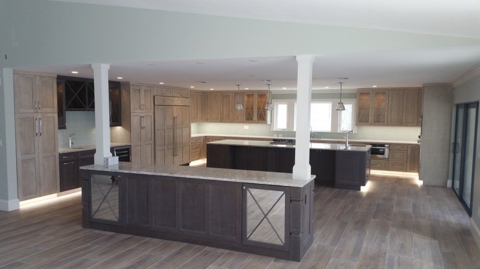 Stunning buffet area overlooking large light stained wood traditional kitchen with toe kick lighting.