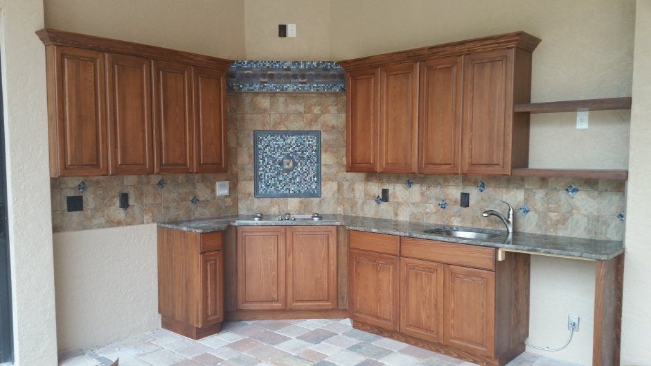 Unique accented tile back splash. Medium stained cabinetry with crown molding.