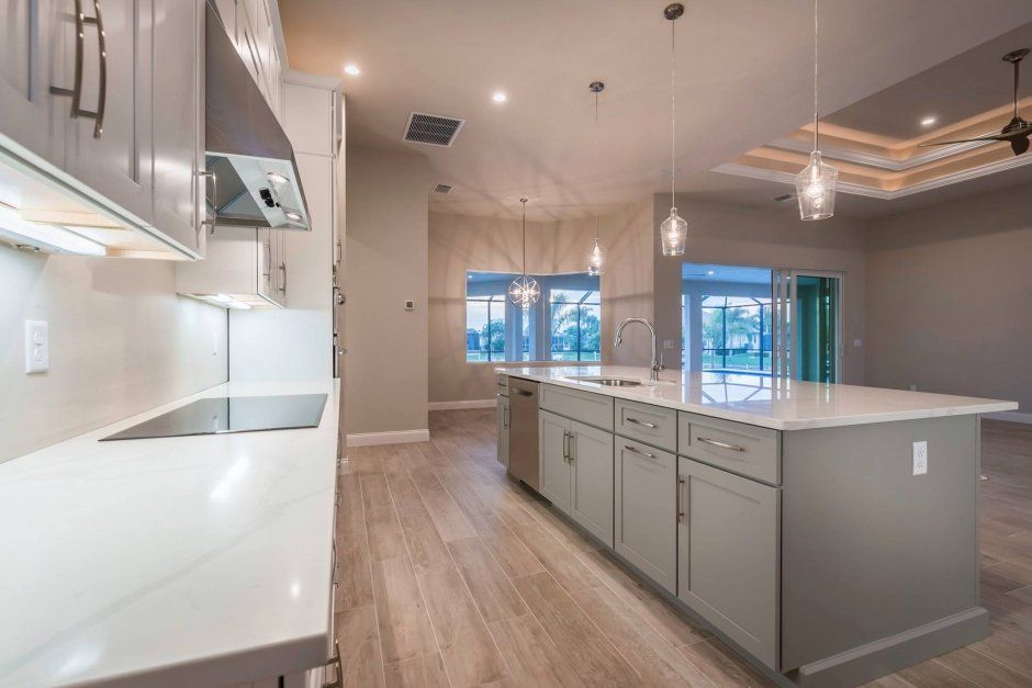 Grey painted shaker cabinets with clean white quartz countertops. New construction.