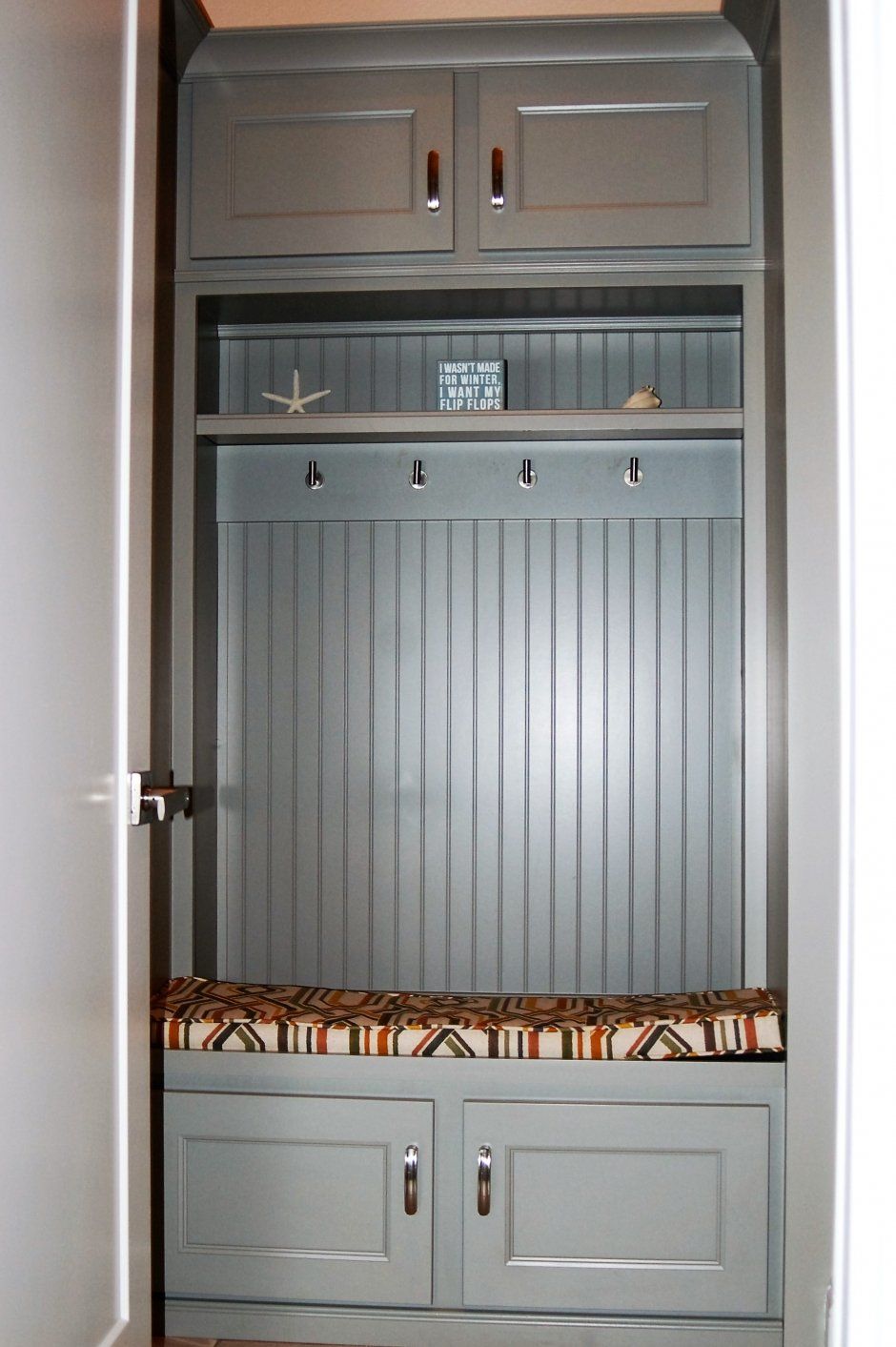 Grey face framed cabinet welcome center with bead board. Floridian humor and decor with chrome hardware.