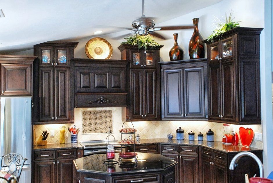 Espresso stained cabinetry in kitchen remodel with tile backsplash and crown molding.