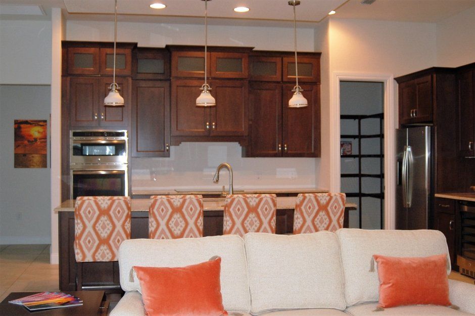 Open concept kitchen with large amounts of storage. Stacked wall cabinets with glass doors.