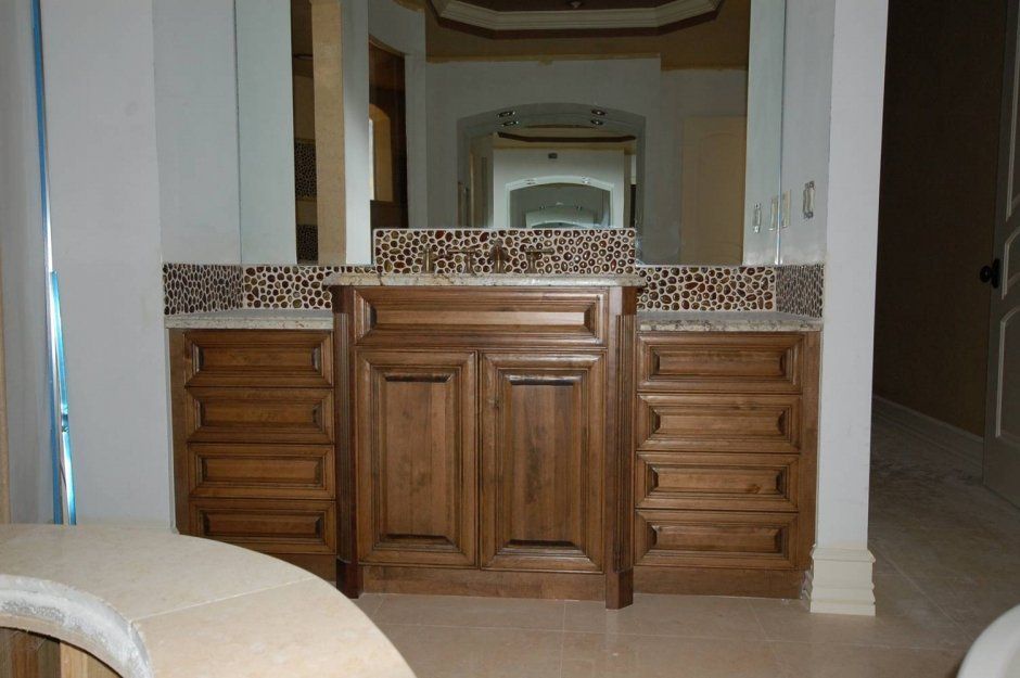 Unique backsplash above multi-level vanity cabinetry. Traditional raised panel vanity remodel.