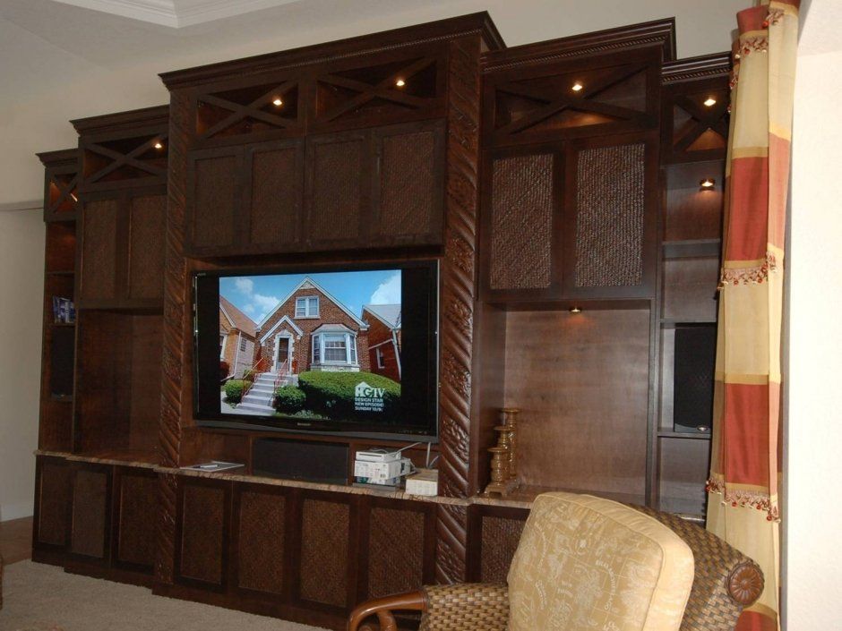 Large dark stained wood built-in entertainment center. Elegant detailed columns and crown with rope molding.