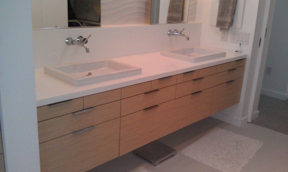 Modern style floating vanity with slab drawers and edge pulls. Wall mounted plumbing