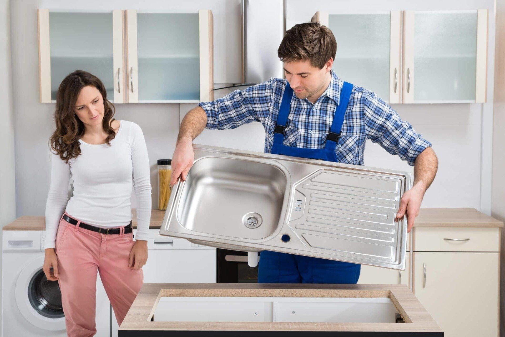 Plumber replacing a kitchen sink — Tenant improvements in Spanaway, WA Plumber replacing a kitchen sink — Tenant improvements in Spanaway, WA