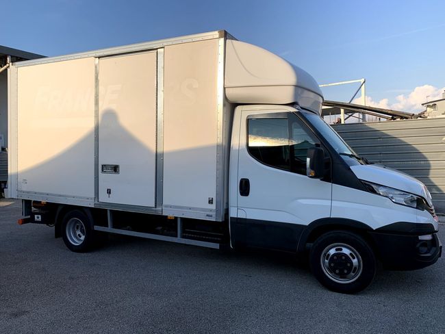 Camion delle consegne bianco parcheggiato in un piazzale in pieno giorno